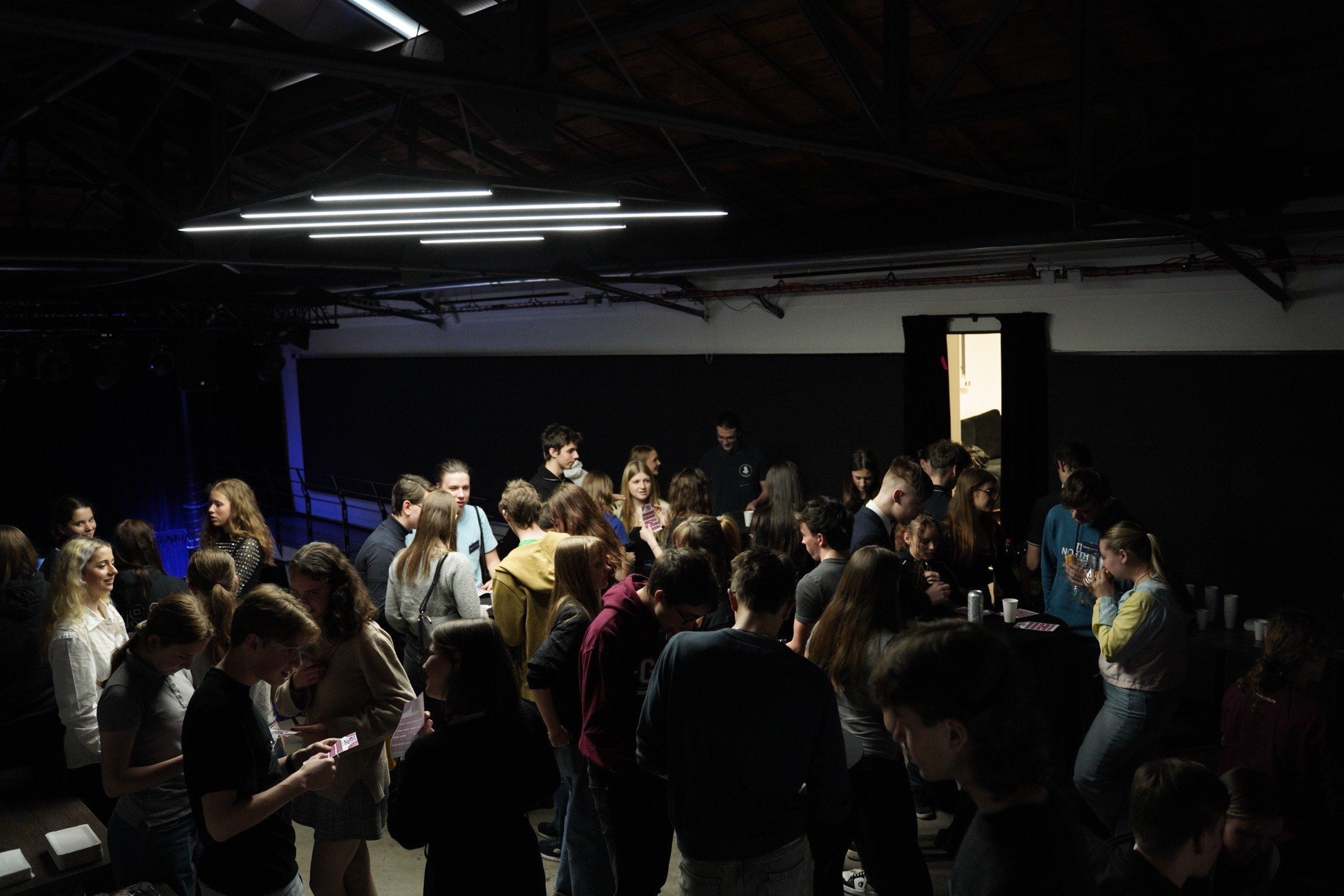 Networking KSS 2026 — studenti v hale s neonovým osvětlením